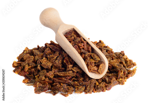 Propolis granules in a wooden shovel are isolated on a white background. Bee glue. Bee products. Apitherapy.