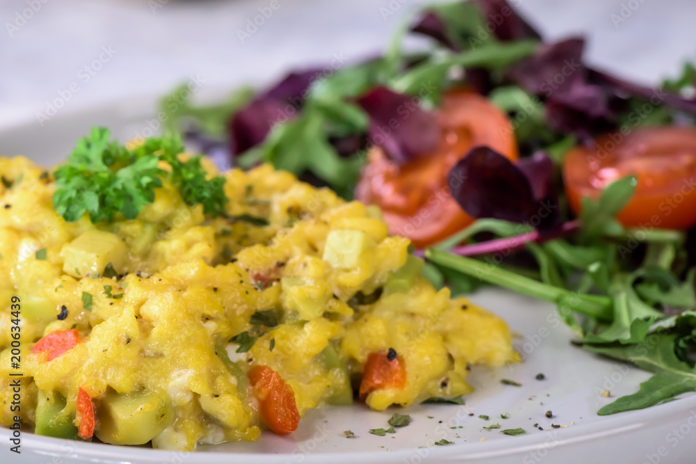Scrambled eggs with pepper, avocado and parsley with saladdade witch eco spinach and rucola - close up. Scrambled eggs with pepper, avocado and parsley with saladdade witch eco spinach and rucola - close up.
