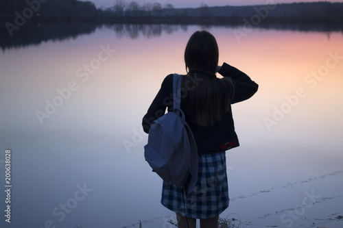Wallpaper Mural Young woman is watching the sunset near a pond. Torontodigital.ca