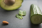 sliced avocado with almonds, mint and cucumber on dark background, selective focus