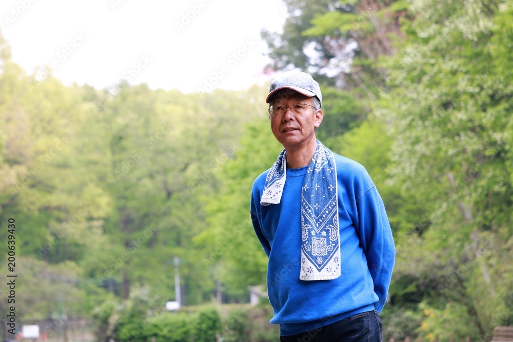 新緑の公園を散歩するシニア男性 新緑の公園を散歩するシニア男性