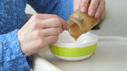 Wallpaper Mural mom puts puree from jar in bowl to feed child Torontodigital.ca