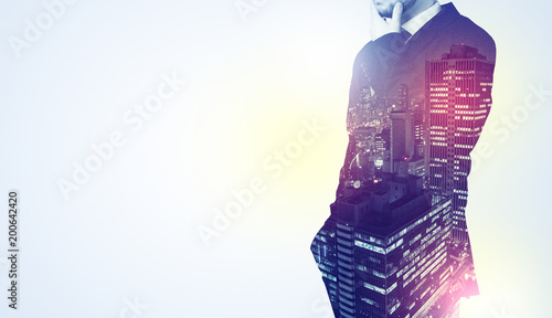  Young businessman standing and thinking with night city background