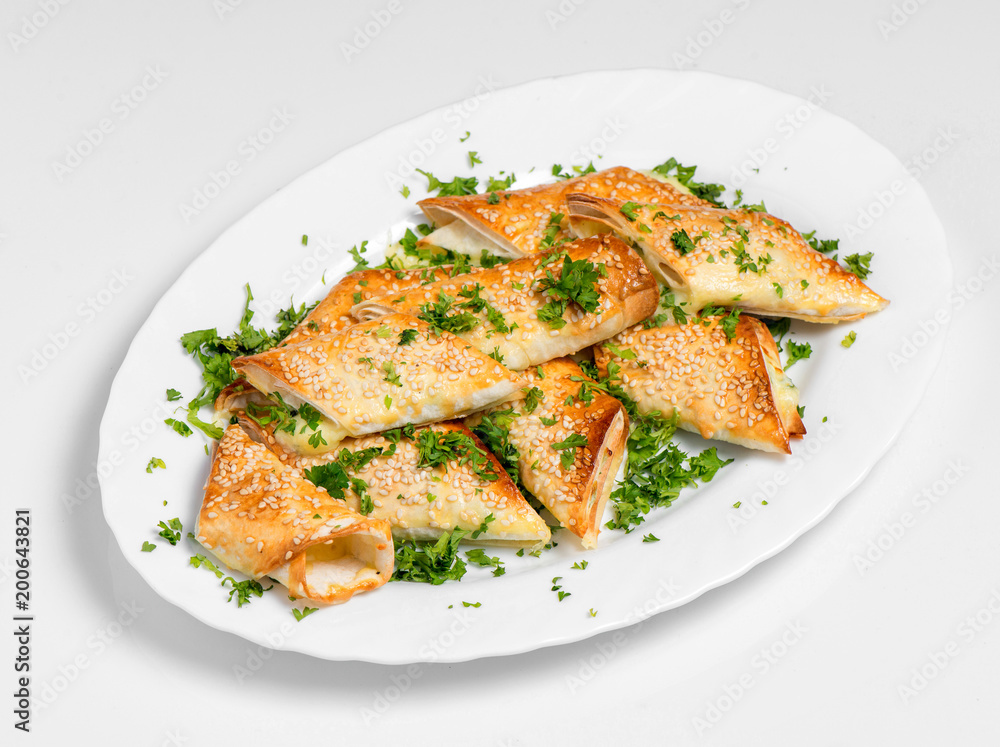 A puff pastry pie with cheese coated with sesame seeds