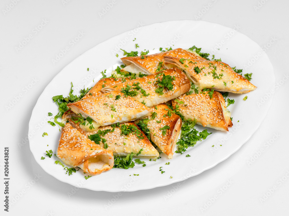 A puff pastry pie with cheese coated with sesame seeds A puff pastry pie with cheese coated with sesame seeds