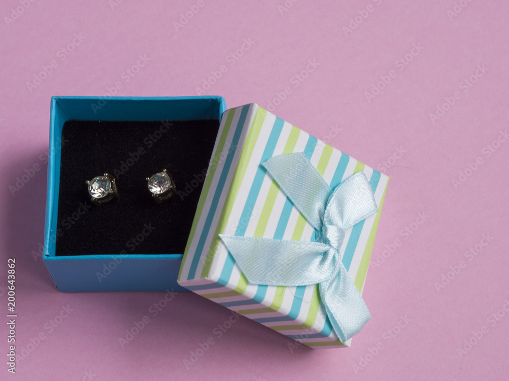 Earings in gift box on pink background Earings in gift box on pink background