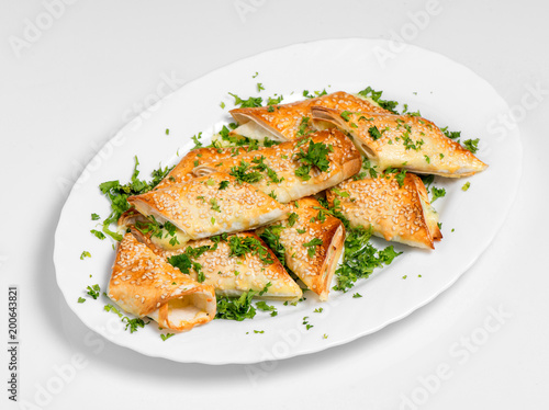 A puff pastry pie with cheese coated with sesame seeds