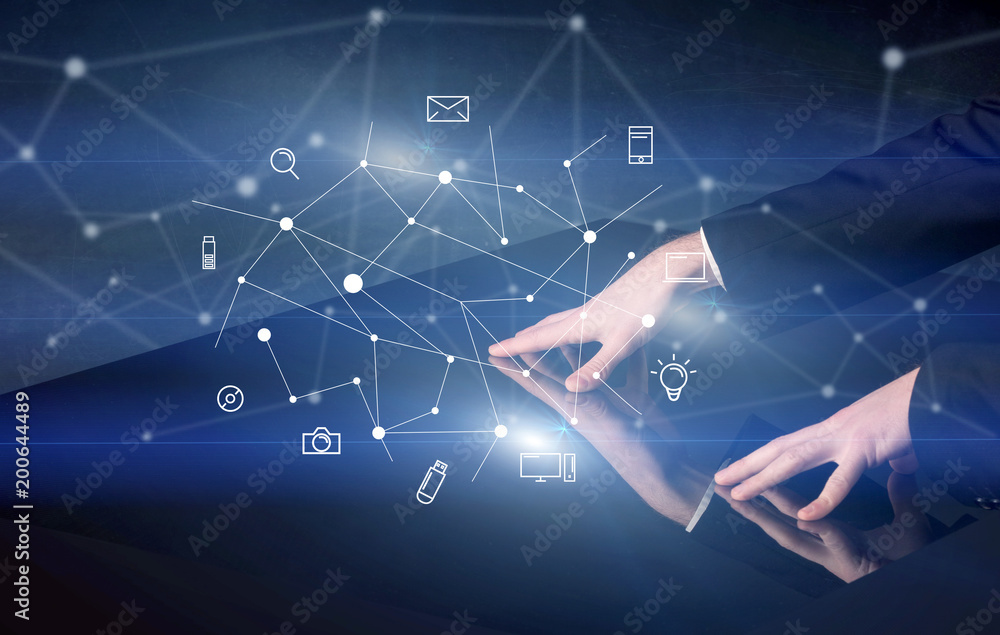 Male hands touching interactive table with blue mixed communication icons in the background Male hands touching interactive table with blue mixed communication icons in the background