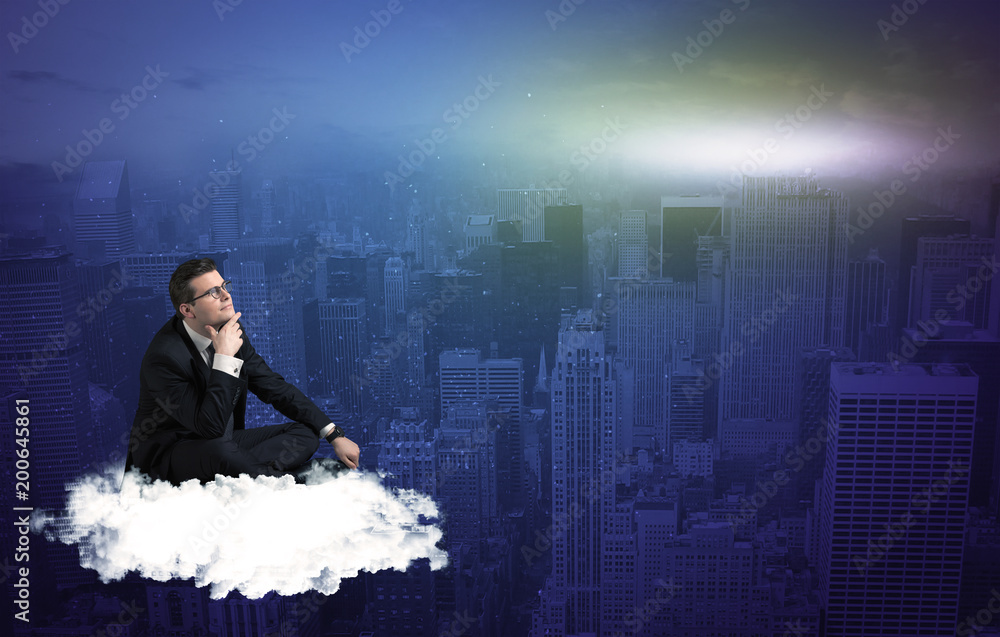 Fototapeta premium Caucasian businessman sitting on a white fluffy cloud above the city, thinking and wondering