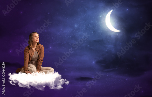 Caucasian woman sitting and wondering on a white cloud  under the moonshine
