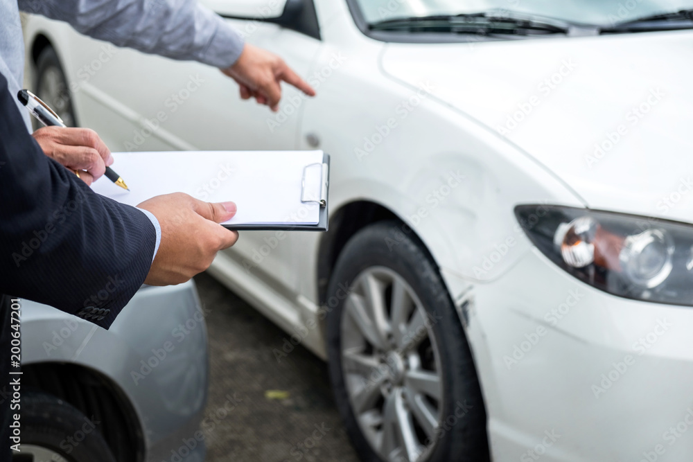Insurance Agent examine Damaged Car and filing Report Claim Form after accident, Traffic Accident and insurance concept Insurance Agent examine Damaged Car and filing Report Claim Form after accident, Traffic Accident and insurance concept