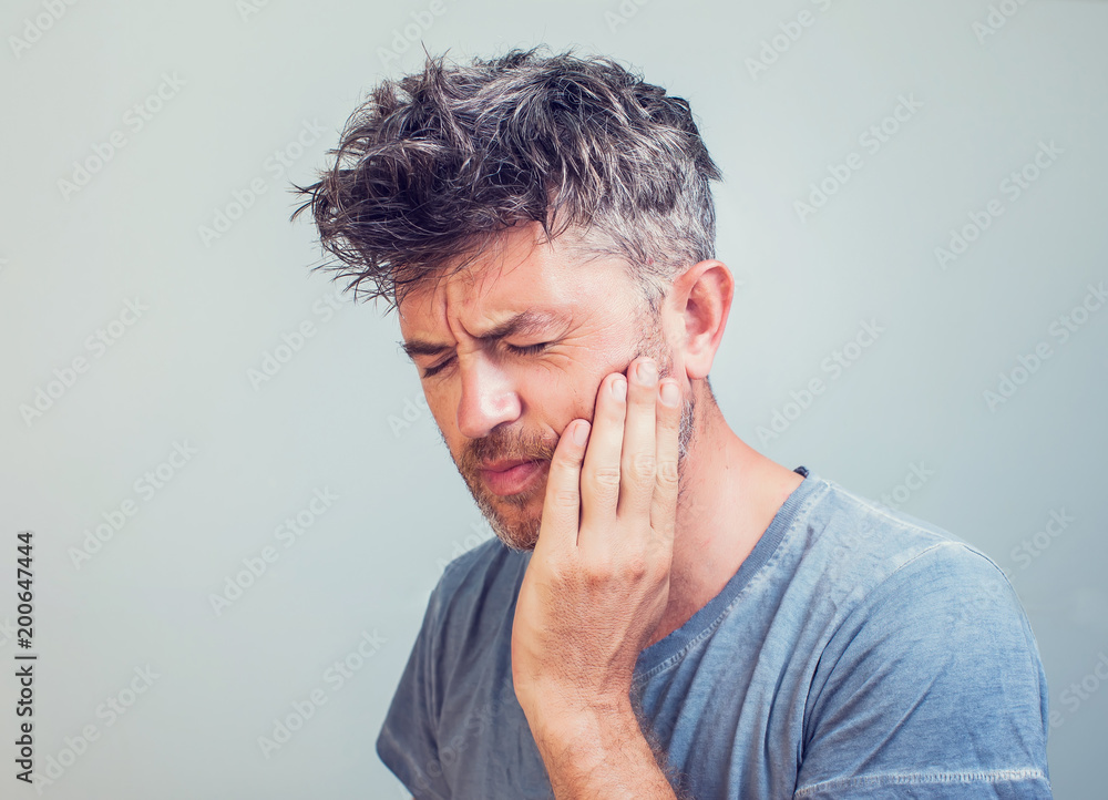 Man holds his hand near the cheek toothache Man holds his hand near the cheek toothache