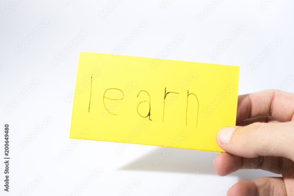 Learn handwrite with a hand on a yellow paper Learn handwrite with a hand on a yellow paper