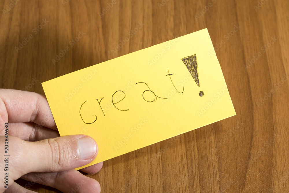 Great handwrite on a yellow paper with a pen on a table Great handwrite on a yellow paper with a pen on a table
