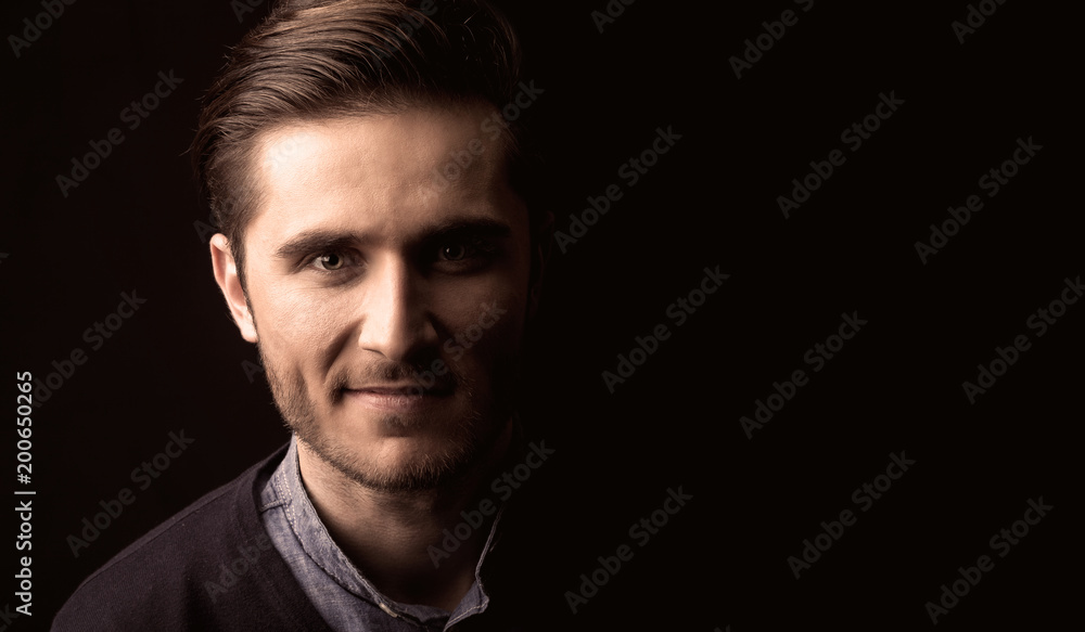 young man close up portrait, on black background young man close up portrait, on black background