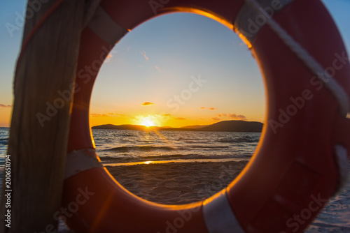 Colorful sunset at the sea seen through a lifebuoy