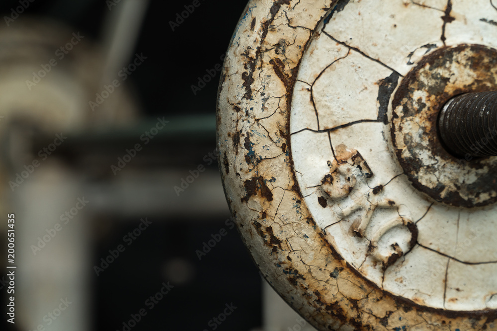 Rusted barbell in a gym. It look like no one to maintenance for long time ago..Vintage barbell. Image for be background. Copy space. Sport and Health Concept.