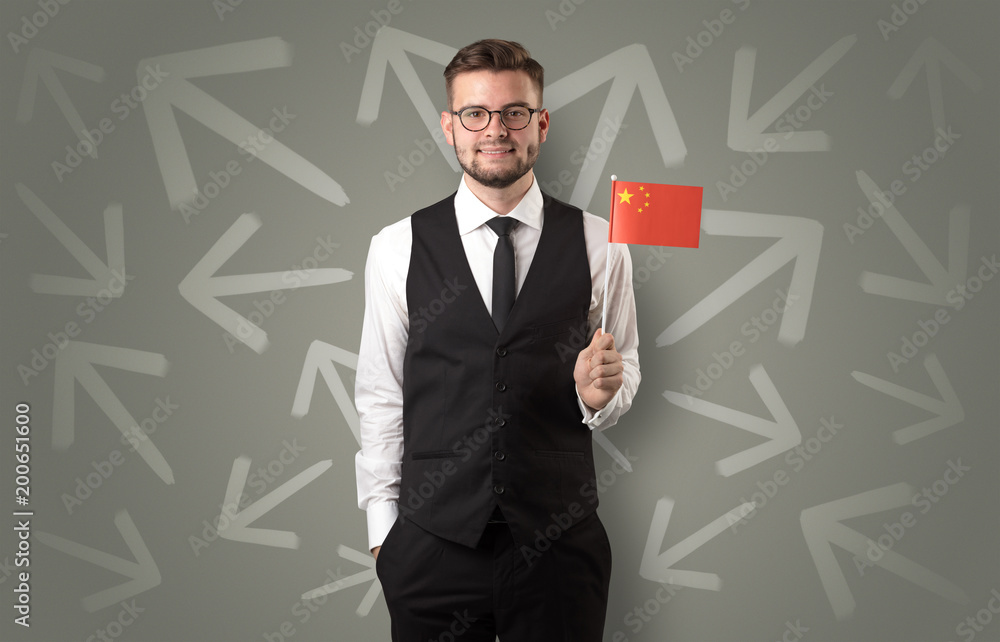 Cheerful elegant boy standing with flag on his hand and chalk drawn arrows around Cheerful elegant boy standing with flag on his hand and chalk drawn arrows around