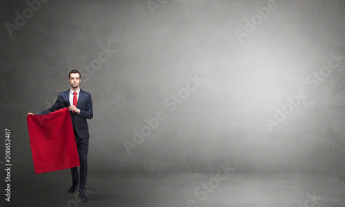 Businessman standing with red toreador cloth in his hand in an empty room   © ra2 studio
