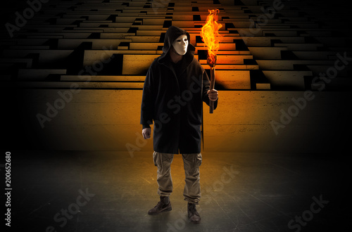 Foto Ugly, aberrant man coming out from the labyrinth with burning flambeau on his ha