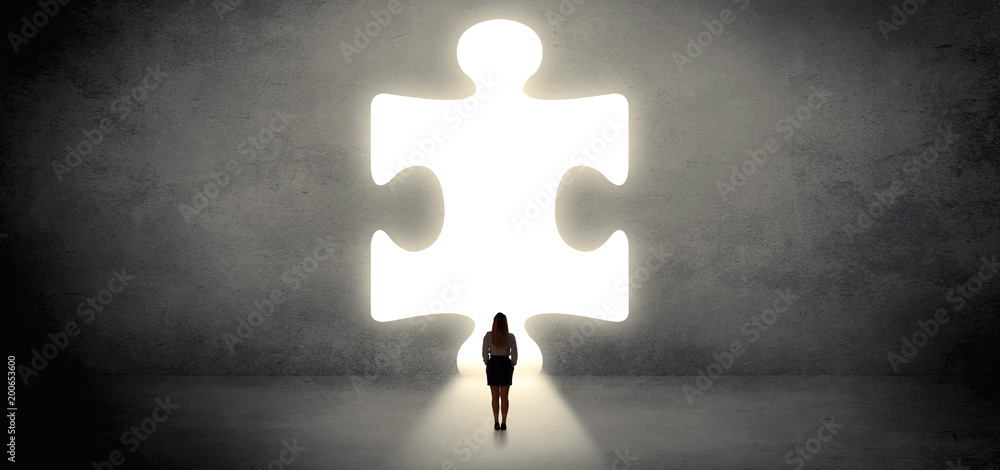Woman standing and looking to a big puzzle piece