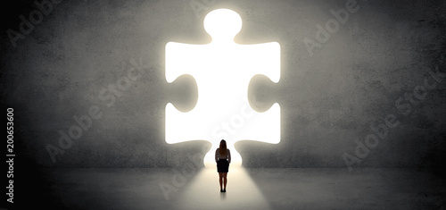 Obraz na płótnie Woman standing and looking to a big puzzle piece
w salonie