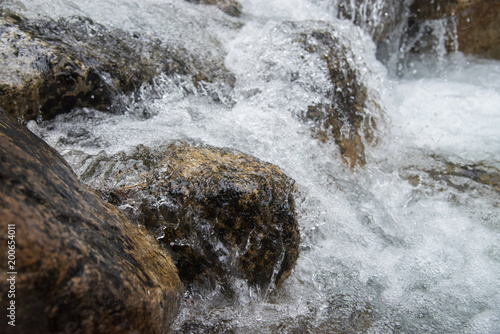 Splashes of water under mountain river  close up shot