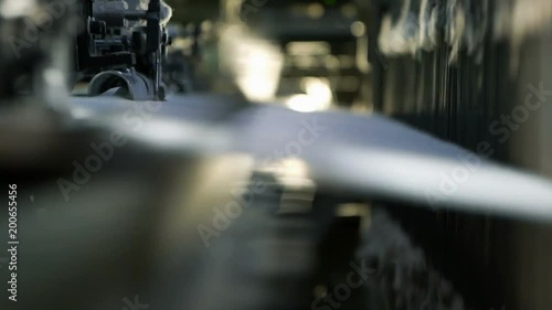 Сlose-up of the process fabric creation on a modern weaving loom in a factory