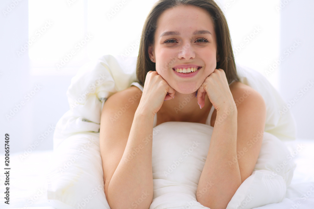Pretty woman lying down on her bed at home Pretty woman lying down on her bed at home