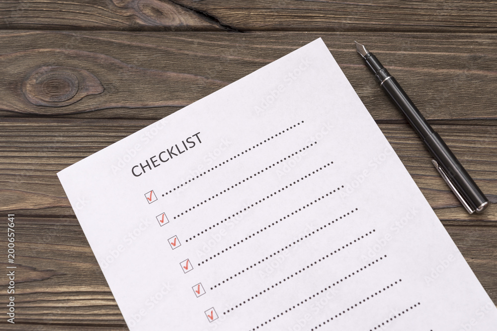 checklist, fountain pen on the background of a wooden table. business. financial planning. checklist, fountain pen on the background of a wooden table. business. financial planning.