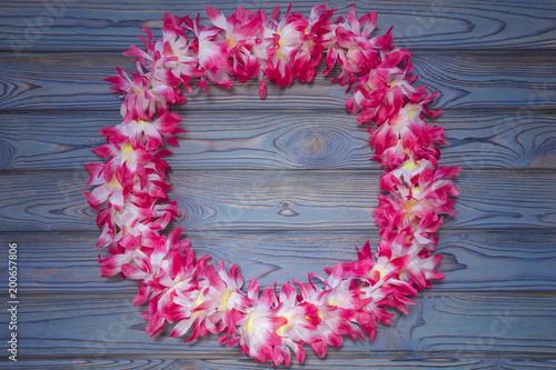 Hawaiian wreath of flowers. beach vacation. resort. Sea. On a blue wooden background