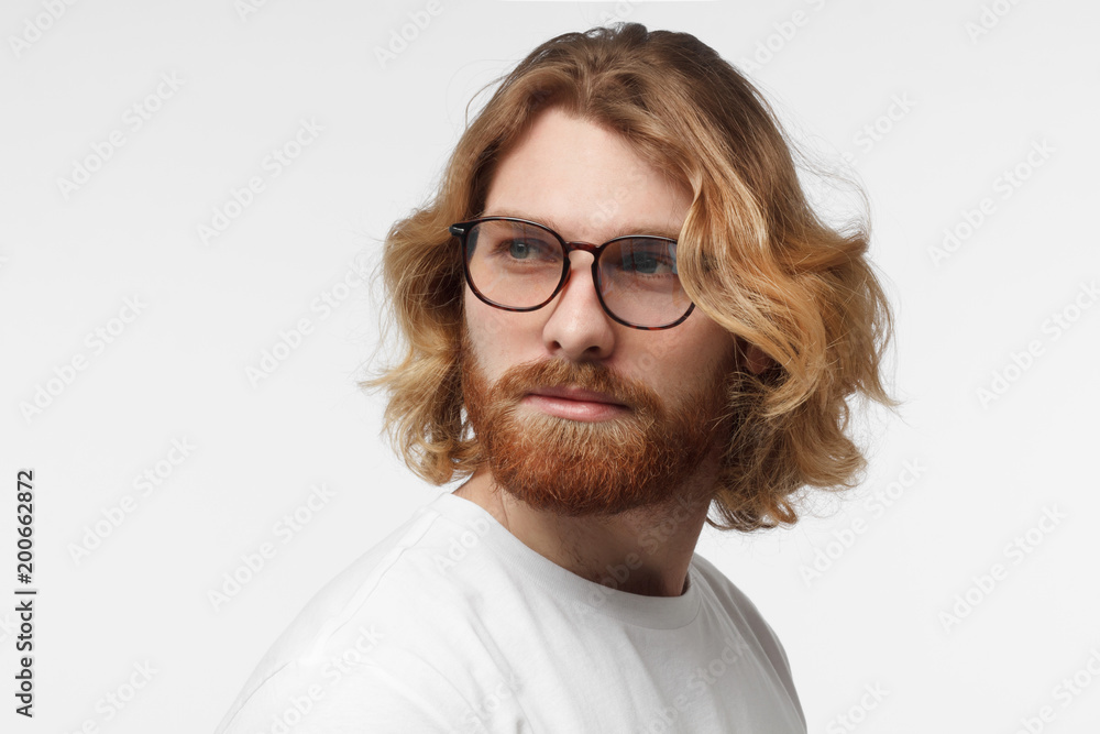 Close up portrait of smiling man in white tshirt looking left isolated on gray background