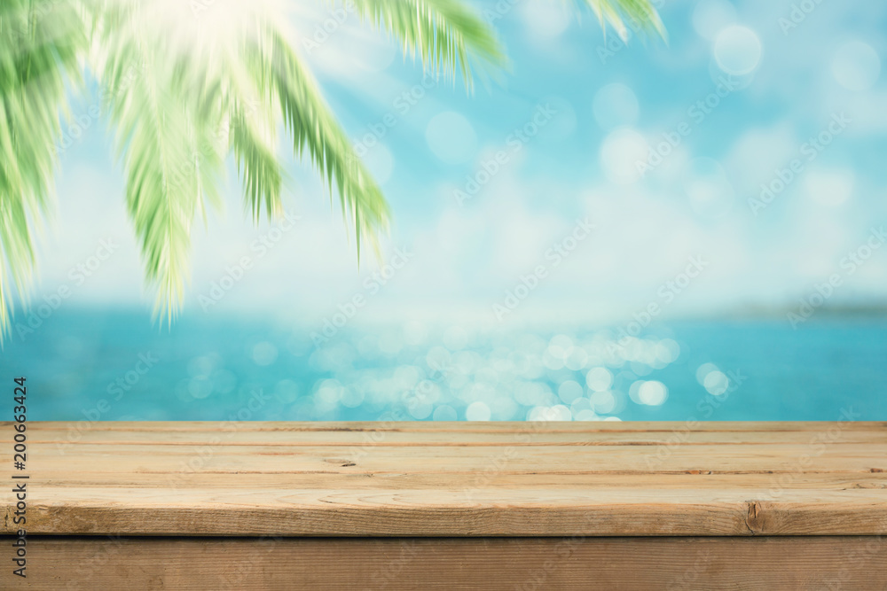 Empty wooden table over blur palm tree Empty wooden table over blur palm tree
