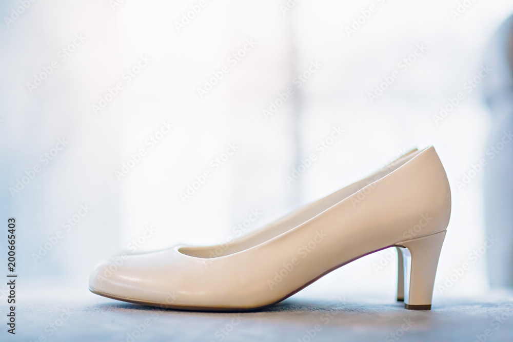 Preparation of the bride. White shoes against the window Preparation of the bride. White shoes against the window
