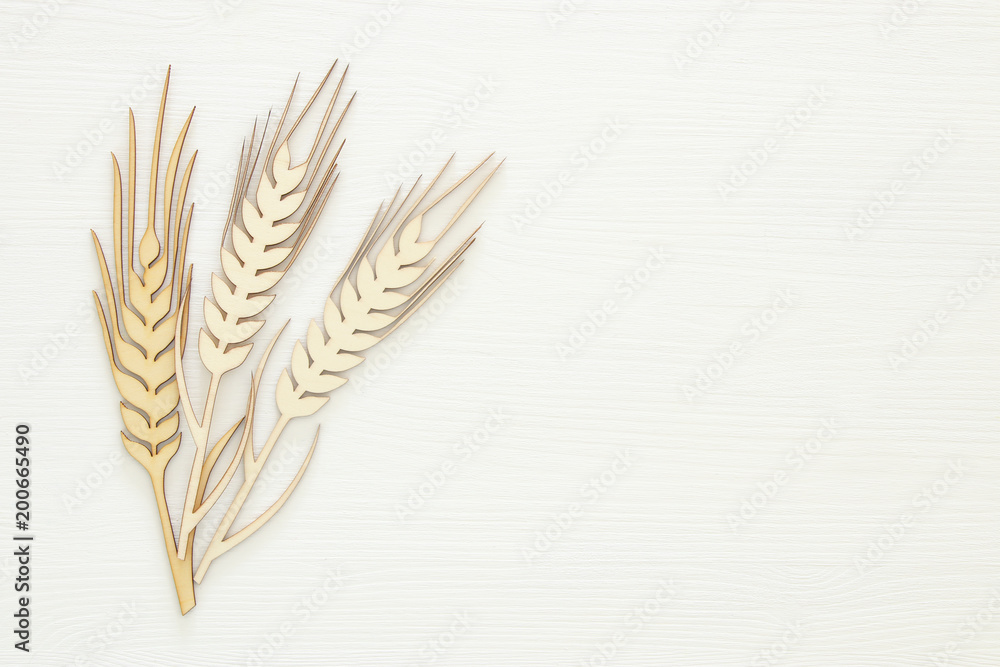 top view of wooden wheat crop decoration over white background. Symbols of jewish holiday - Shavuot. top view of wooden wheat crop decoration over white background. Symbols of jewish holiday - Shavuot.