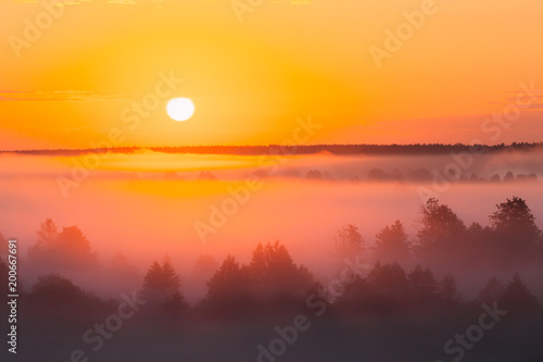 Amazing Sunrise Over Misty Landscape. Scenic View Of Foggy Morning