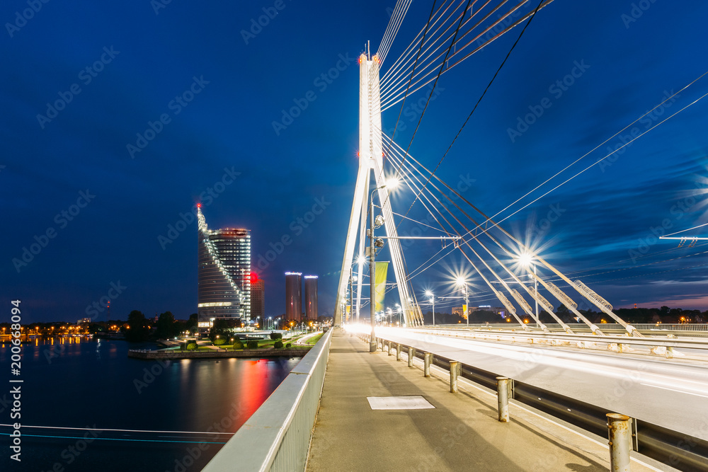 Riga Latvia. Close View Of Deserted Vansu Cable-Stayed Bridge In Bright Night Illumination Over The Daugava River