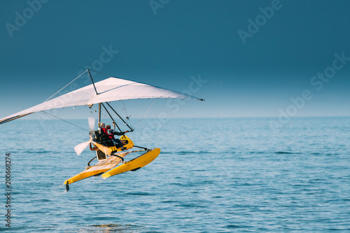 Motorized Hang Glider With Muslim Woman Take Off Frow Sea In Sunny Summer Day photo