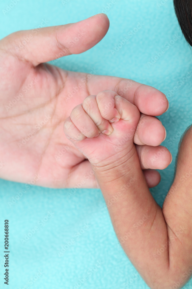 Mother holding newborn baby's hand-New life care Mother holding newborn baby's hand-New life care