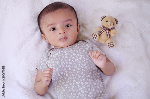 Newborn baby boy with teddy bear on bed