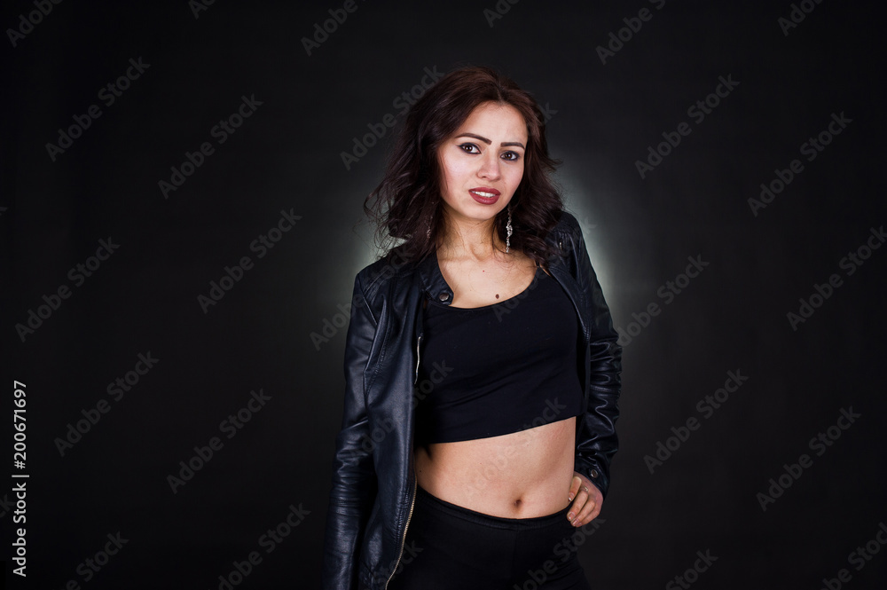 Studio portrait of sexy brunette girl in black leather jacket against black background. Studio portrait of sexy brunette girl in black leather jacket against black background.