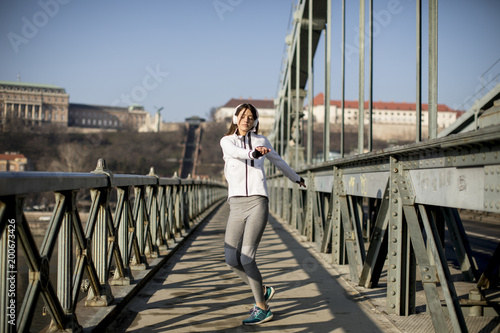 Young sportswoman stretching and preparing to run © BGStock72