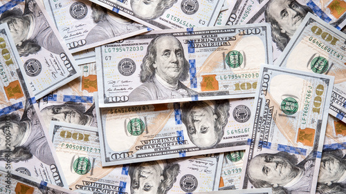 Background of lots of banknotes of 100 dollars spread on a surface, concept for poor and wealthy, uprising and declining economy