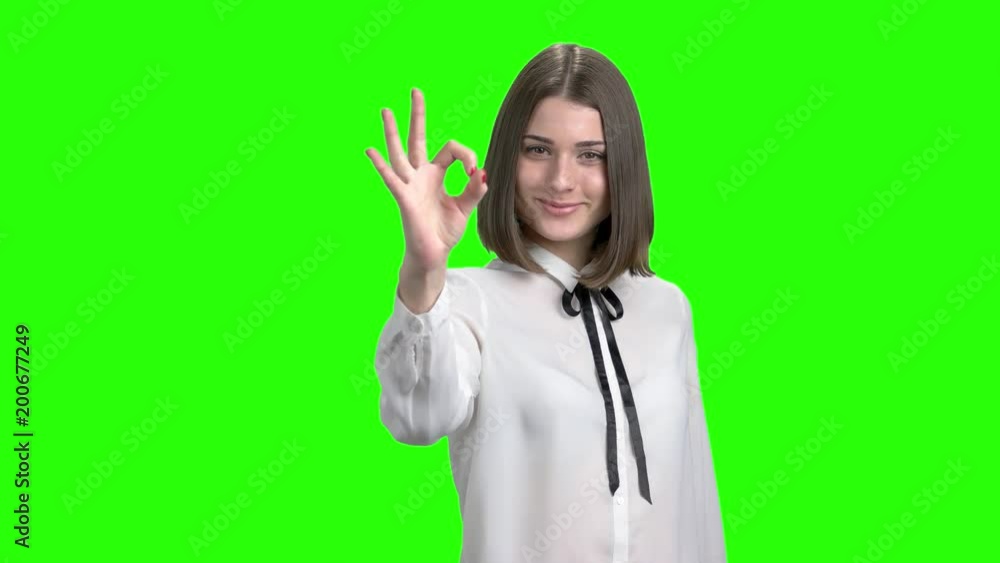 Teen girl in white blouse shows youth gestures. Green screen hromakey background for keying. Teen girl in white blouse shows youth gestures. Green screen hromakey background for keying.