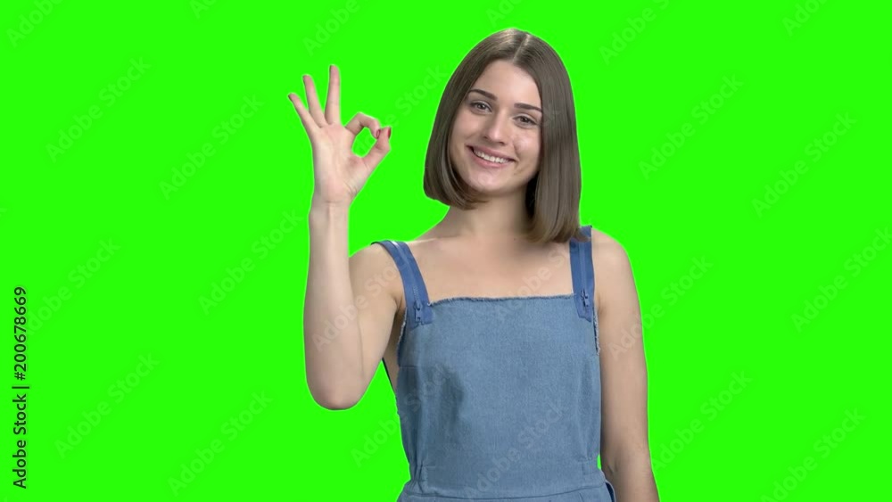 Thumb up and ok gesture. Portrait of teen girl shows signs. Green screen hromakey background for keying. Thumb up and ok gesture. Portrait of teen girl shows signs. Green screen hromakey background for keying.