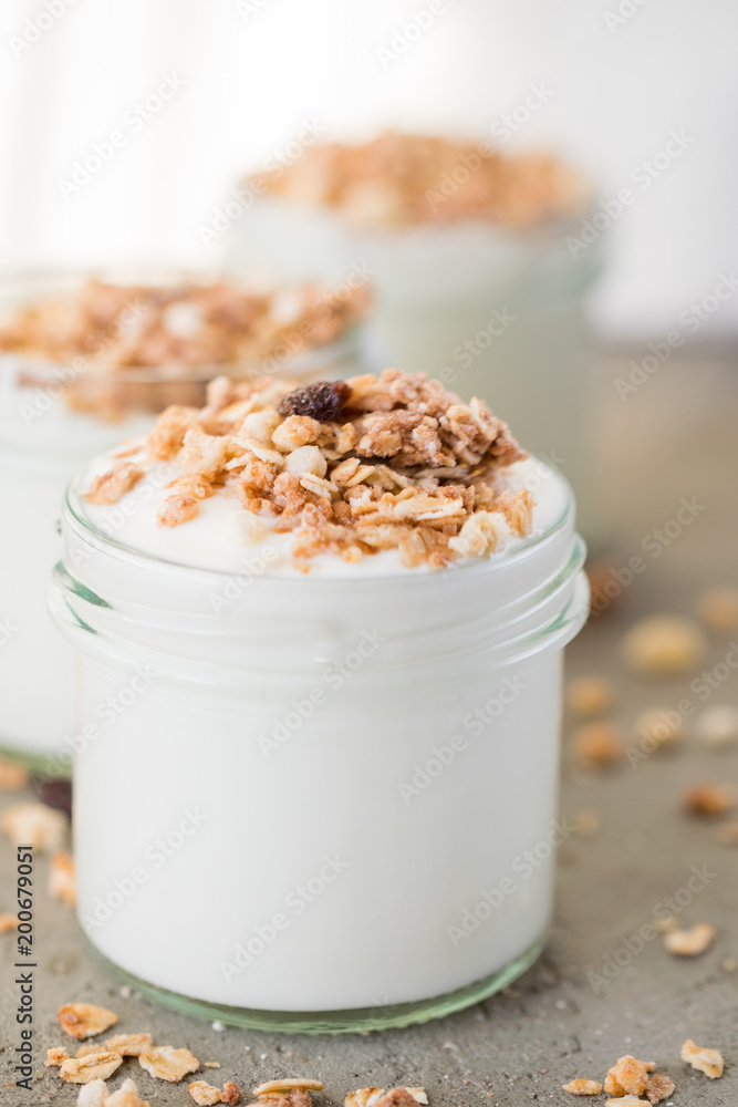 Yoghurt with granola made of oats, raisins, puffed rice, chocolate and dried bananas. Healthy breakfast for family. Yoghurt with granola made of oats, raisins, puffed rice, chocolate and dried bananas. Healthy breakfast for family.