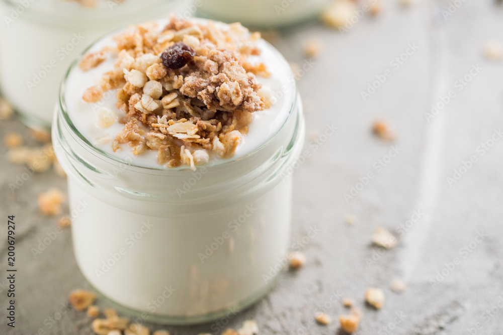 Yoghurt with granola made of oats, raisins, puffed rice, chocolate and dried bananas. Healthy breakfast for family. Yoghurt with granola made of oats, raisins, puffed rice, chocolate and dried bananas. Healthy breakfast for family.