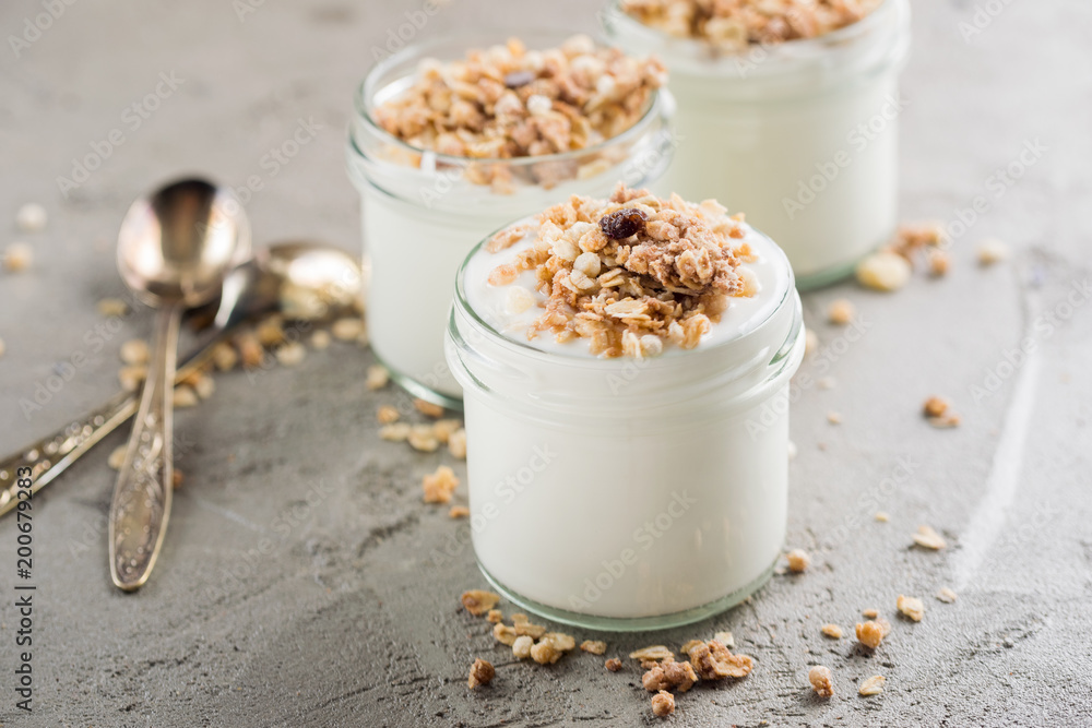 Yoghurt with granola made of oats, raisins, puffed rice, chocolate and dried bananas. Healthy breakfast for family. Yoghurt with granola made of oats, raisins, puffed rice, chocolate and dried bananas. Healthy breakfast for family.