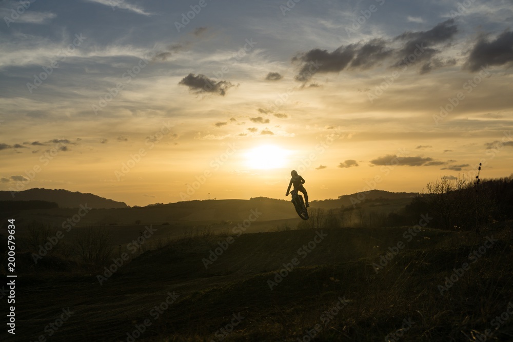 Motorcyclist riding off road during sunset. Slovakia