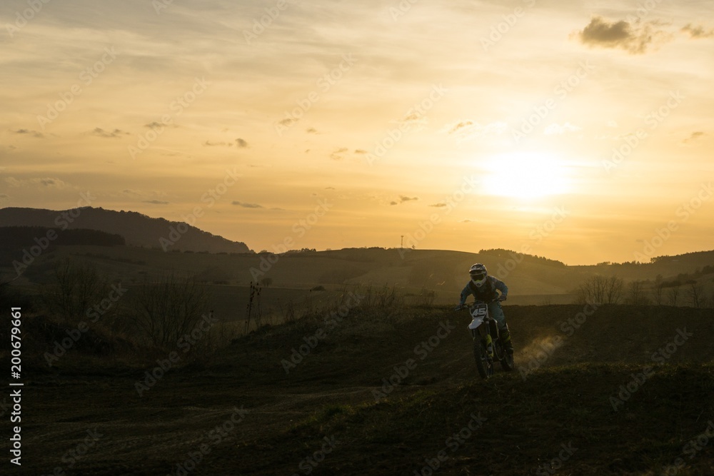 Motorcyclist riding off road during sunset. Slovakia
